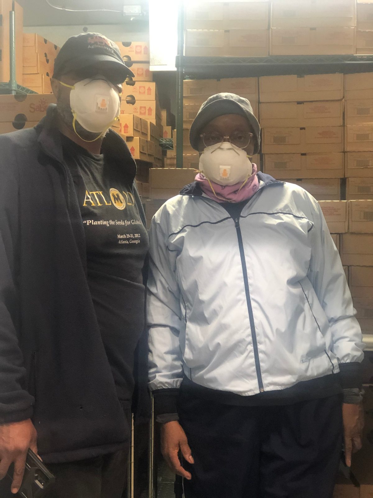 Two volunteers pose in face masks for safety